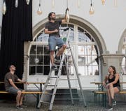 Das Dreierteam im OK des Kulturfestivals: Walter Boos (auf der Leiter), Lukas Hofstetter und Lina Samland beim Aufbau im historischen Innenhof. (Bild: Adriana Ortiz Cardozo)