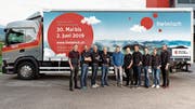 Das Iheimisch-OK mit seinem neuen, unübersehbaren Werbeträger im Hintergrund. In der Mitte Reto Zimmermann, dessen Firma als Co-Sponsor mitwirkt. (Bild: PD)