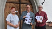 Barbara Binzegger, Christoph Honegger und Renée Franck vom Verein Freunde vor der Klosterkirche Paradies mit dem Konzertprogramm 2018/19. (Bild: Thomas Güntert)