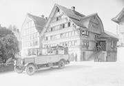 Hemberg, Gasthaus und Metzgerei zum Löwen mit parkiertem Postauto im Jahre 1930. (Bild: Staatsarchiv SG)