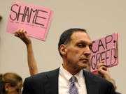 Protest gegen den Lehman Brothers-Chef Richard Fuld Jr. bei seiner Aussage vor einem US-Parlaments-Kommission.as he prepares to testify before the House Committee on Oversight and Government Reform's hearing on 'The Causes and Effects of the Lehman Brothers Bankruptcy' on Capitol Hill in Washington, D.C. USA 06 October 2008. Fuld blamed the bankruptcy of his company on a "lack of confidence" saying that he and other executives did everything they could to protect the failed investment bank. (KEYSTONE/EPA/SHAWN THEW) Bild: Shawn Thew/EPA (Washington D. C., 6. Oktober 2008)