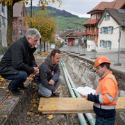 Gemeinderat Adolf Scherl, Patrik Dommen (Leiter Bauamt) und Bauleiter Roman Krummenacher (von links) begutachten die Dorfbach-Baustelle. (Bild: Corinne Glanzmann, Buochs, 5. November 2019)