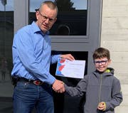 Der Drittklässler Loris Sedlmeyer erhält von Schulleiter Sebastian Schaad das Diplom des Känguru-Mathewettbewerbs. (Bild: PD)