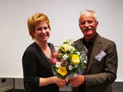 Hans-Peter Häfliger übergibt Karin von Moos einen Blumenstrauss für die Neuwahl in den Vorstand.
