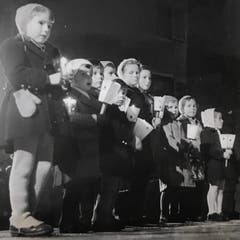 Auch jüngsten Teilnehmenden - jeweils etwa vier Jahre alt - tragen stolz ihre Laternchen mit. (Bild: Chronik der Sternsinger 1950 (Stadtarchiv/D131))