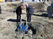 Die Bauherren Othmar Thoma und Hans Habegger vergraben auf der Baustelle eine Kiste als Zeitkapsel mit verschiedenen Unterlagen über das Projekt. (Bild: Nicole D'Orazio)