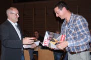 Kommandant Christian Feuz übergibt Roland Kauderer eine Broschüre, die dessen Wirken würdigt. (Bild: Trudi Krieg)