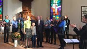 Pfarrer Bruno Ammann und seine Familie (Mitte) werden vom Chor ThurKlang musikalisch in Bürglen begrüsst. (Bild: PD)