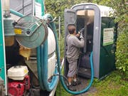 Ein Mitarbeiter der Firma ASA Service AG reinigt am Donnerstagvormittag das mobile WC am Goldacher Seeufer. (Bild: Rudolf Hirtl)