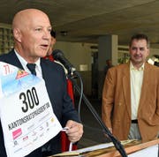 Der Alpnacher Gemeindepräsident Heinz Krummenacher (links) übergibt Reto Wallimann die Startnummer für das Inferno-Rennen Mürren 2020. (Bild: Robert Hess, Alpnach, 28. Juni 2019)