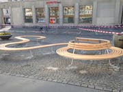 Die verschlungene Sitzbank in der Lücke zwischen den Häuschen des ständigen Markts.