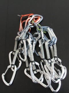 Expressschlingen und Helm: Expressschlingen bestehen aus zwei Schnappkarabinern, die mit einer Bandschlinge verbunden sind. Die Expressschlingen werden in den Bohrhaken am Fels eingehängt, sodass das Seil in den anderen Karabiner gelegt werden kann und damit die Sicherung gewährleistet ist. Ebenso wichtig beim Klettern ist ein Helm.
