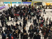 Gestrandete Passagiere am Flughafen Gatwick. Bild: Kirsty Wigglesworth / AP)