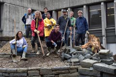 Eine Projektgruppe der Kanti Wattwil schafft neben dem Schulhauseingang Grünflächen für mehr Biodiversität. Selbst bei widrigen Bedingungen baut sie Steinmauern für Eidechsen, pickelt den Boden um und wühlt im Schlamm, um einen seichten Teich zu gestalten. Biolehrerin und Projektleiterin Gabriela Lutz (im gelben Mantel) ist stolz, mit wie viel Einsatz die Schüler bei der Arbeit sind. (Bild: Timon Kobelt, 25.09.2019)