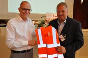 Der abtretende und der neue Verwaltungsratspräsident der Frauenfeld-Wil-Bahn: Erwin Rutishauser übergibt Carlo Parolari eine Leuchtweste als Geschenk. (Bild: Sebastian Keller)