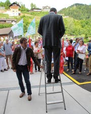 Gemeindepräsident Alois Gunzenreiner spricht zu den Demonstranten auf dem Platz vor dem Eingang zum Spital Wattwil. Die Leiter hält Schulratspräsident Norbert Stieger. (Bild: Martin Knoepfel)