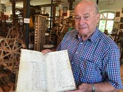 Gottlob Lutz zeigt ein altes Buchhaltungsbuch.