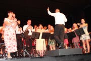 Mit Showeinlagen, bunten Kleidern und stimmiger Musik präsentierte sich der Musikverein unter der Leitung von Bruno Uhr dem Publikum. (Bild: Manuela Olgiati)