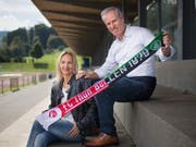 Bea und Carlo Hefti posieren mit Thun/St. Gallen-Schal in der Tübacher Sportanlage Kellen, wo ihre Kinder in der Jugend fast täglich dem Ball hinterherjagten. (Bild: Benjamin Manser)