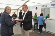 OK-Präsident Peter Kroll (rechts) überreicht dem ersten Besucher einen Biberfladen als Geschenk. (Bild: Sabine Camedda)