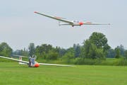 Der eine Segelflieger steht zum Start bereit, ein anderer setzt in diesem Moment zur Landung an. (Bild: Mario Testa)
