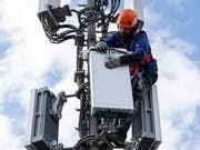 Ein Installationsfachmann montiert ein 5G-Element an einer Mobilfunkantenne. (Bild: Peter Klaunzer/Keystone)