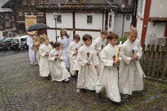 Bei leichtem Schneefall zogen die sieben Zweitklässler begleitet von Pfarrer Jan Strancich und den Ministranten in die Pfarrkirche Spiringen ein. (Bild: Franz Imholz, 28. April 2019)