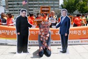 Donald Trump als Störenfried zwischen Kum Jong Un und Moon Jae In: Protestaktion gegen die Absage des geplanten Gipfels zwischen Nordkorea und den USA. (Jeon Heon-Kyun/EPA)