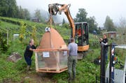 Sorgfältig wird das Tongefäss mit dem Bagger zum Loch transportiert.