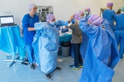 Schüler schlüpfen in Operationskleider.