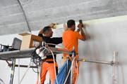 Bevor die Farbe aufgetragen werden kann, wird der Übergang zum Beton sauber abgeklebt. (Bild: Urs M. Hemm)