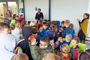 Schulleiter Renato Winteler erklärt den Kindern die neue Plakette an der Wand. Diese freuen sich über die Auszeichnung. (Bild: Mario Testa)