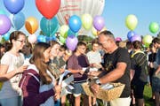 Vor der Abfahrt mit dem Heissluftballon nimmt Schulleiter Hansmartin Keller Glückwunsch-Karten der Schülerinnen und Schüler entgegen. (Bild: Mario Testa)