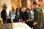 Bürger betrachten das Modell des Friedhofs Mogelsberg, der umgestaltet werden soll. (Bild: Urs M. Hemm)