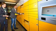 Stadtpräsident Gabriel Macedo lässt sich von Janine Knup, Leiterin Betrieb, die neue Paketstation erklären. Als Belohnung findet er etwas Süsses im Fach. (Bild: Manuel Nagel)