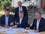 Unter Aufsicht von Justizdirektor Paul Winiker (SVP) erledigen am Tisch (von links) Thomas Roos (Gemeindepräsident Ebersecken), Stefan Mehr (Gemeindeschreiber) und Urs Kaufmann (Gemeindepräsident Altishofen) die Papierarbeit. (Bild: Martina Odermatt, Altishofen, 23. September 2018)