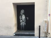 Auf einem Nebeneingang des Pariser Musikclubs «Bataclan» ist ein Wandbild zu sehen, das dem britischen Street-Art-Künstler Banksy zugeschrieben wird. Ob zu Recht, wird heiss diskutiert. (Bild: Keystone/dpa/Sebastian Kunigkeit)