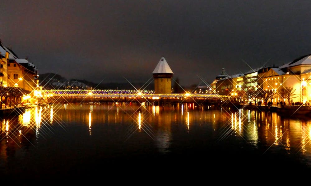 Blick auf das Luzerner Wahrzeichen und all die funkelnden Lichter von der Reussbrücke aus. (Bild: Walter Buholzer (Luzern, 17. Dezember 2018))