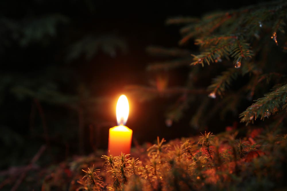 Am Weihnachtstag leuchtet eine Kerze auf dem Waldboden. (Bild: Irene Wanner (Schötz, 25. Dezember 2018))