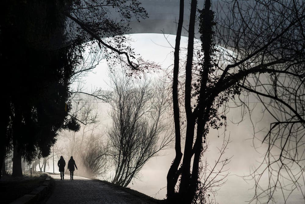 Spaziergänger laufen in Bern der Aare entlang. (Bild: Keystone / Alessandro della Valle)