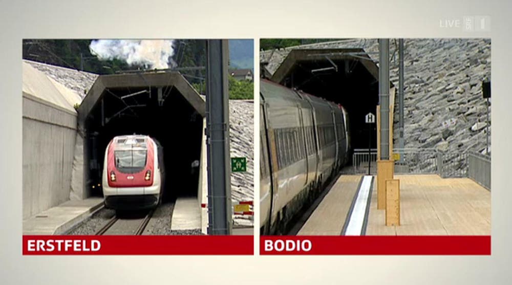 Fast synchron: Die Eröffnungszüge fahren aus dem Tunnel. (Bild: Alptransit Livestream)