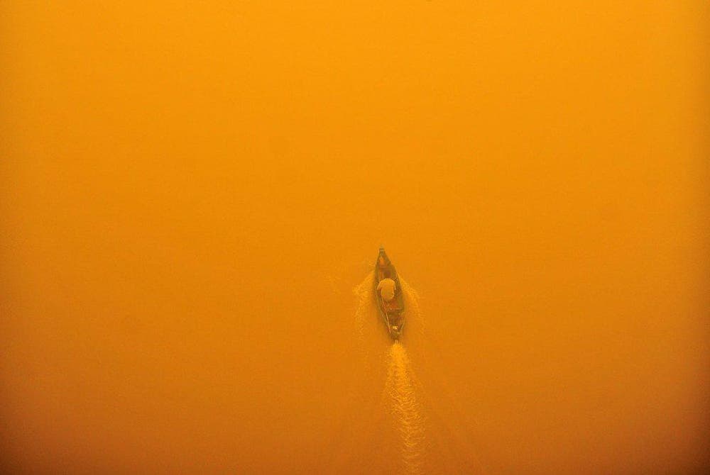 Ein Mann auf einem Boot in Palangkaraya in Indonesien. In der Gegend wüteten schwere Waldbrände. Jetzt ist der Fluss verseucht. (Bild: EPA / Hugo Hudoyoko)