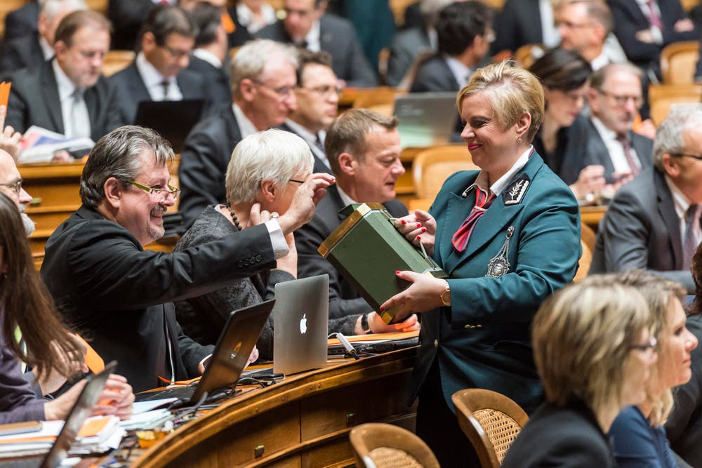 Beat Flach, GLP-AG, links, gibt seinen Stimmzettel in die Urne, welche ihm Ratsweibelin Nathalie Radelfinger hinhält. (Bild: KEYSTONE / LUKAS LEHMANN)