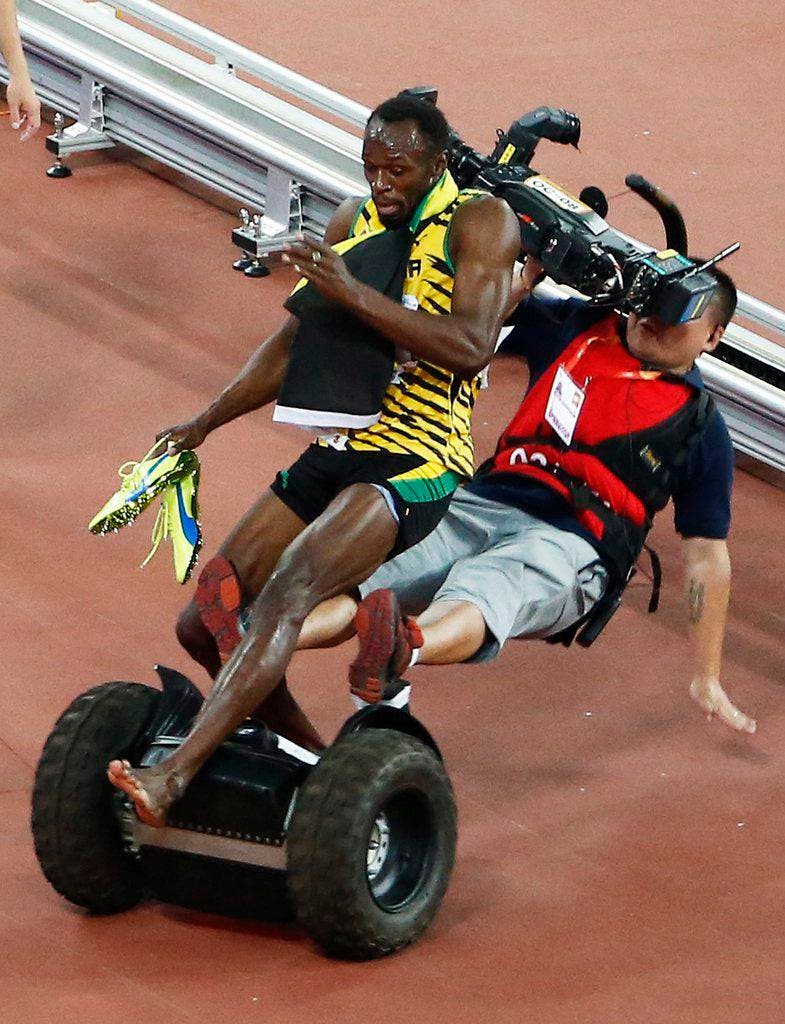 Ein Kameramann fährt den jamaikanischen Sprintstar Usain Bolt bei den Weltmeisterschaften in Peking über den Haufen (27. August). (Bild: EPA / Rolex dela Pena)