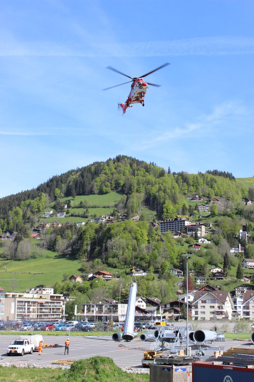 Der Super-Puma beim Parkplatz der Titlis-Bahnen in Engelberg hebt einen Masten. (Bild: Mike Bacher)