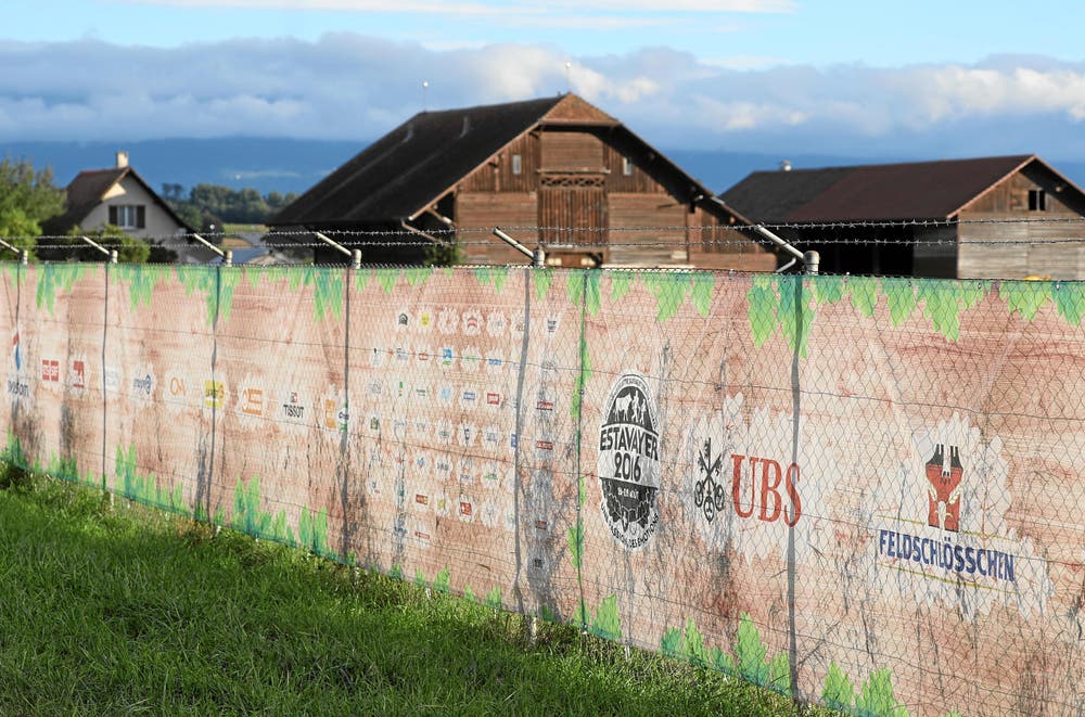 Die Gitterdrähte sind mit grossen Kunststoffplanen geschickt verdeckt. Die Auftritte der Sponsoren sind für einmal nicht in schreienden Farben gehalten, sondern schön in Holz- und Laubfarben eingelegt. Gerade deshalb fäll die Werbung auf. (Bild: Swiss Image / Andy Mettler)