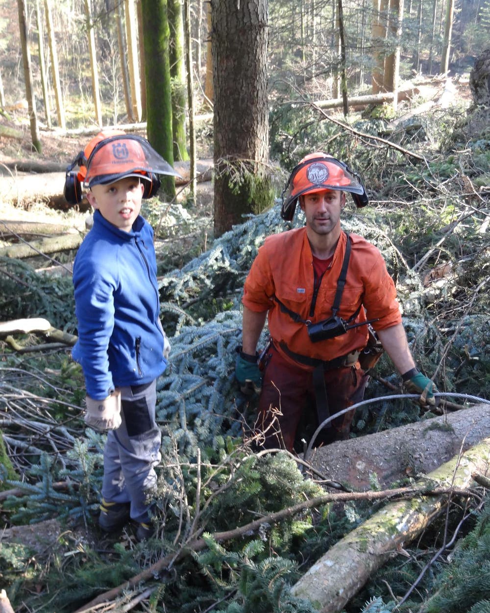 Sven Odermatt und Forstwart Ady Degelo hängen im Hergiswiler Korporationswald Stämme an den Mobilseilkran (Bild: Josef Odermatt, Amt für Wald und Energie NW)