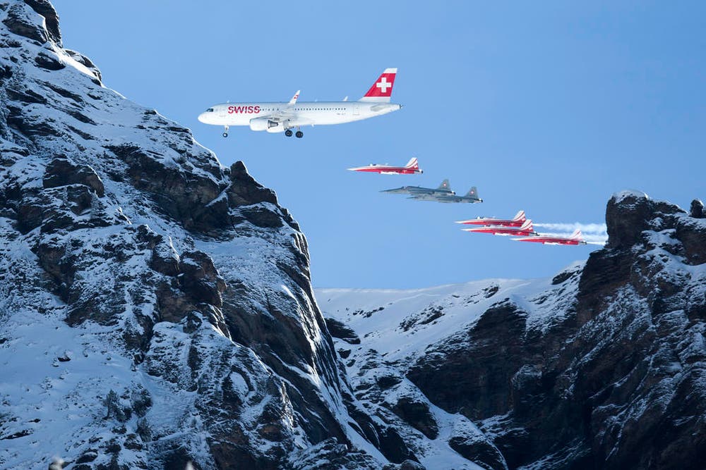 Die Patrouille Suisse begleitet einen Airbus A320 der Swiss bei der Flugshow vor dem Lauberhornrennen 2015. (Bild: Keystone / Peter Klaunzer)