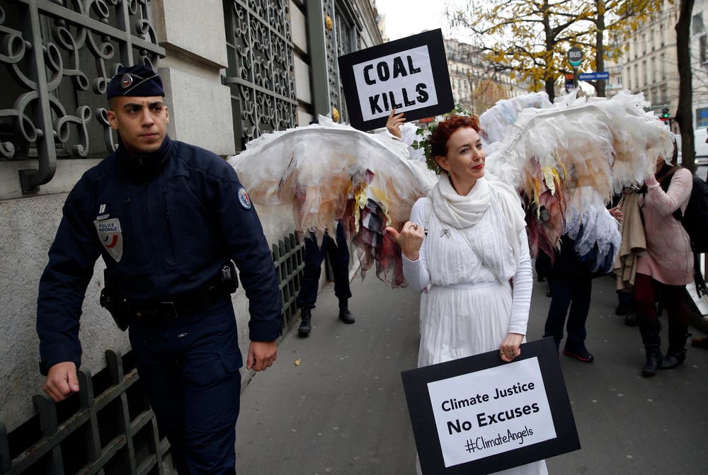 Ein Klimaschutzengel deutet auf einen Sicherheitsmann. (Bild: AP Photo/Christophe Ena)