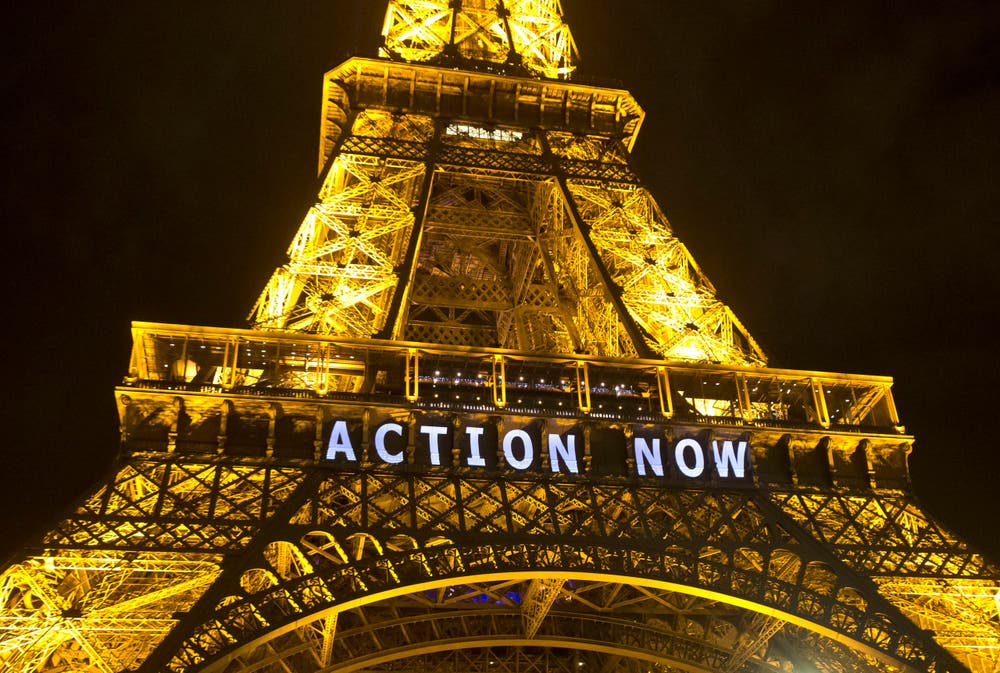 Auch der alte Eiffelturm muss für Slogans hinhalten. (Bild: AP Photo/Michel Euler)